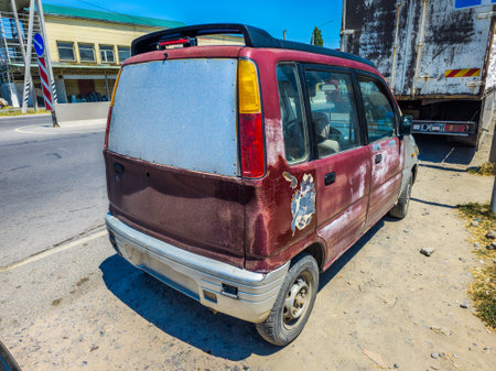 Damaged car parked on urban street during daytimeの写真素材