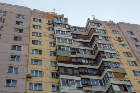 Worn apartment building with balconies in urban setting