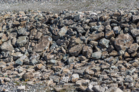 Rock revetment, riverbank stabilization, erosion control, riprap, natural stone, outdoor, daylight