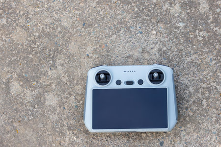 Remote control resting on concrete ground outdoors during daytimeの写真素材