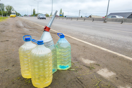 cars passing by plastic bottles on the side of the roadの写真素材