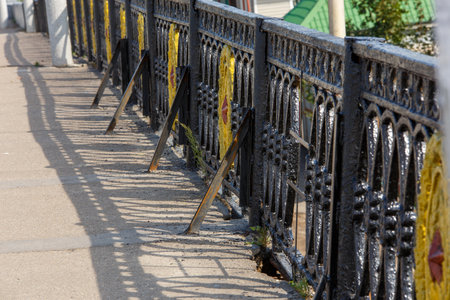 Ornate aluminum fence with yellow details in urban settingの写真素材