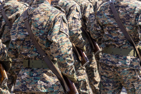 Multiple men in camouflage uniforms carrying rifles outdoors at sunny dayの写真素材