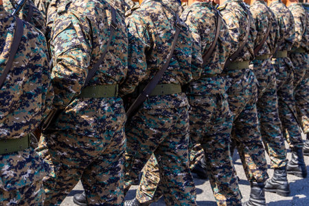 Multiple soldiers marching in formation during military parade, rear viewの写真素材