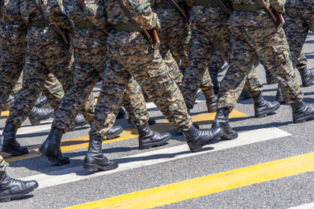 Group of soldiers marching in camouflage uniforms outdoorsの写真素材