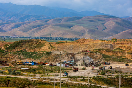 Heavy construction vehicles working at rugged quarry site in Kyrgyzstanの写真素材