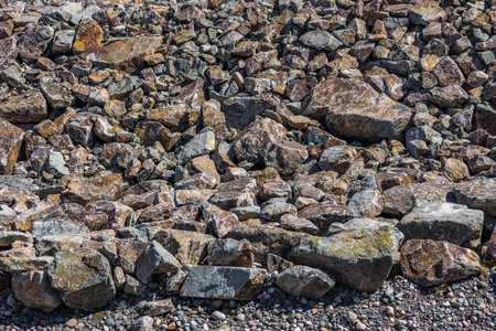 Pile of diverse rough stones and rocks in bright sunlight.