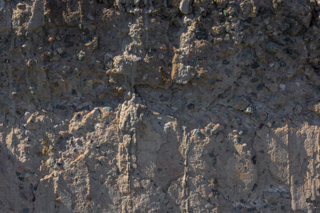 Weathered Uneven Concrete Surface with Pebbles under tangential harsh lightの写真素材