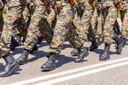 Adults marching in camouflage uniforms during military ceremonyの写真素材