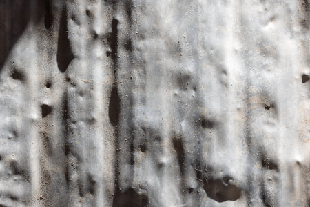 Weathered old aluminum sheet showing signs of wear outdoorsの写真素材