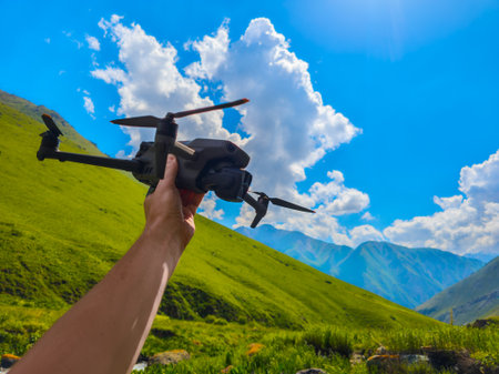 Adult man holding drone in mountainous outdoor region