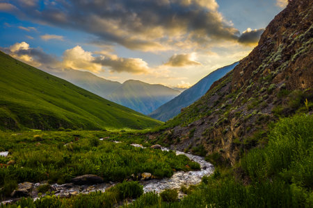 Majestic sunset over serene river and mountainsの写真素材