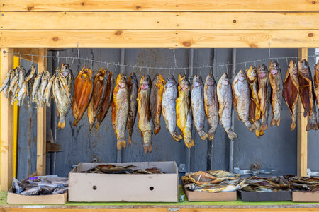 Dried smoked fish displayed in rustic outdoor market stall