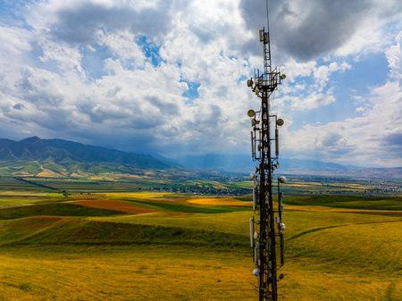 Telecommunications Tower in Rural Landscape with Distant Mountainsの写真素材