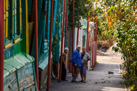 Tula, Russia - August 27, 2021 - Three elderly Russian women in patterned outfits outdoors in alleywayのeditorial素材