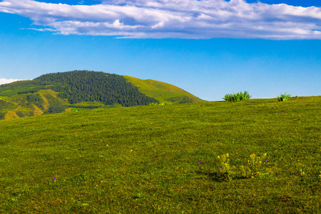 Serene landscape of mountains and hills under cloudy skyの写真素材