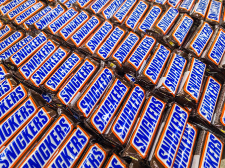 Sokuluk, Kyrgyzstan - June 18, 2024: Colorful display of iconic Snickers chocolate bars forming...