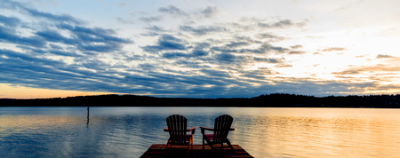 Chairs on a dock at sunset.  