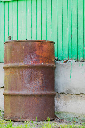 Rusty ply barrel on the background of green cement blocks and boardsの写真素材