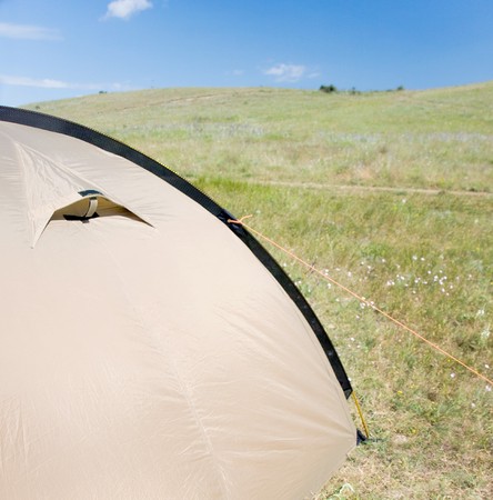 Tent and camping equipment on the green grassの写真素材