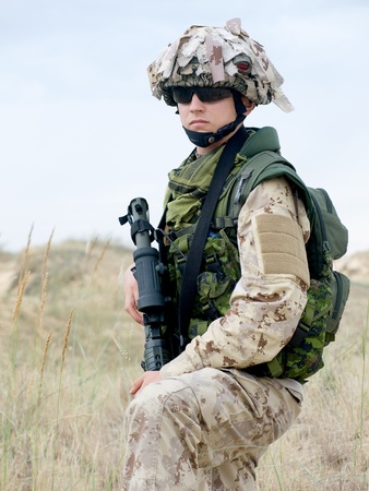 soldier in desert uniform holding his rifleの写真素材