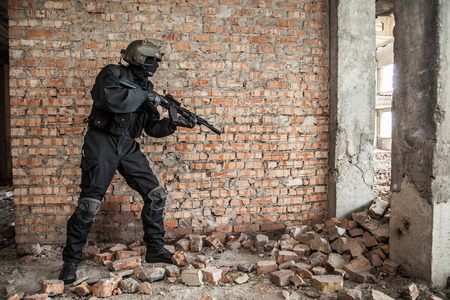 Special forces operator in black uniform and bulletproof