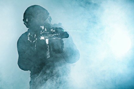 Police officer SWAT in black uniform in the smoke studio shotの写真素材