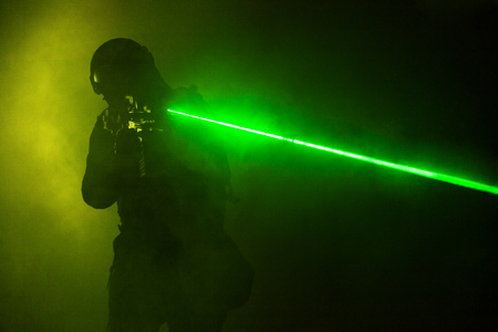 Police officer SWAT in black uniform in the smoke with laser sightsの写真素材