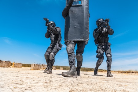 Spec ops police officers SWAT with ballistic shield in action