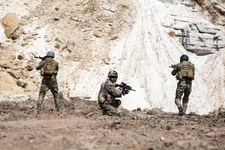 Members of Navy SEAL Team with weapons in action