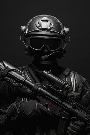 Spec ops police officer SWAT in black uniform and face mask studio shotの写真素材