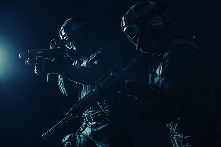 Spec ops police officers SWAT in black uniform and face mask studio shotの写真素材