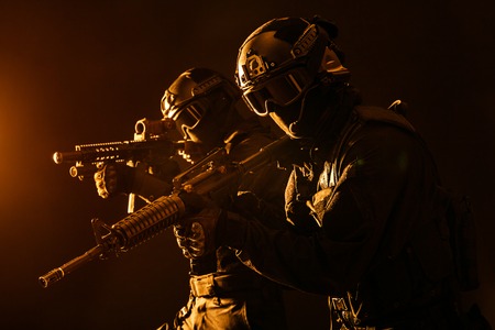 Spec ops police officers SWAT in black uniform and face mask studio shotの写真素材