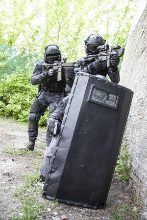 Spec ops police officers SWAT in black uniform in action