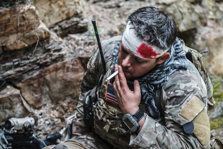 Wounded army ranger machine gunner in the mountainsの写真素材