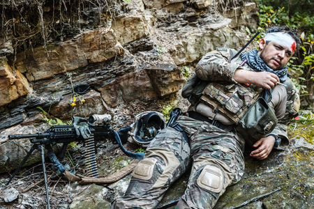 Wounded army ranger machine gunner in the mountainsの写真素材