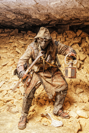 Underground post apocalyptic creature with homemade weapons and lanternの写真素材