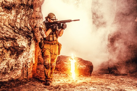 Private military contractor PMC in baseball cap with assault rifle in the rocksの写真素材