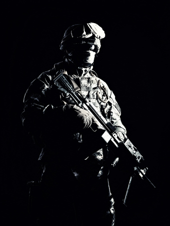 Special operations forces soldier, counter terrorism squad fighter, security service guard, marine shooter in combat uniform, armed with light machine gun low light studio shot on black backgroundの写真素材