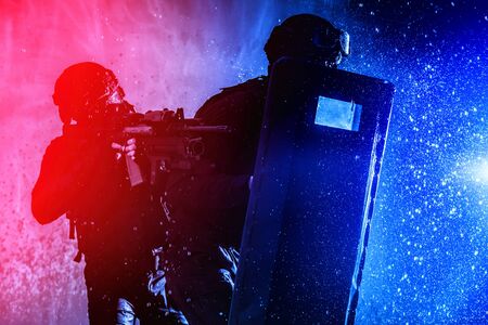 SWAT fighters officers hiding behind ballistic shieldの写真素材