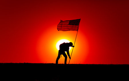 Silhouette of army soldier, United States of America infantryman sticking into ground flagpole with waving USA national flag. Soldiers heroism and victory, military honor and memory of fallen warriorsの写真素材