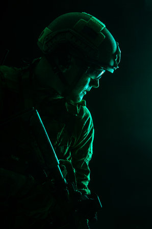 Studio contour backlight shot of special forces soldier in uniforms with weapons, portrait on black backgroundの写真素材