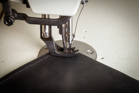stitching leather products in a leather workshop