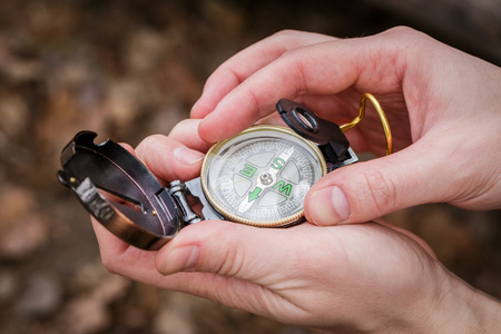 man sets up a compass holding it in his hands