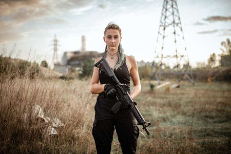 Sexy woman posing with rifle at outdoorの写真素材