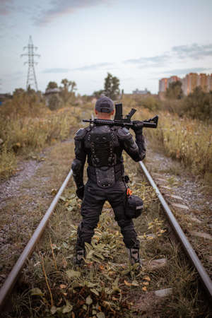 a man with a rifle in uniform stands with his backの写真素材