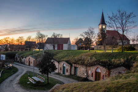 Tiny old stone wine cellars and church in village Vrbice, South Moravia in the Czech Republic at sunsetの写真素材