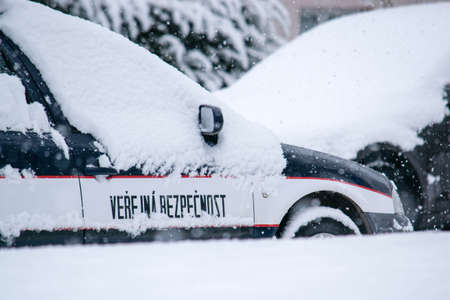 A blue police vehicle stands in a parking lot covered in snow. Skoda Octavia of the Czech police.