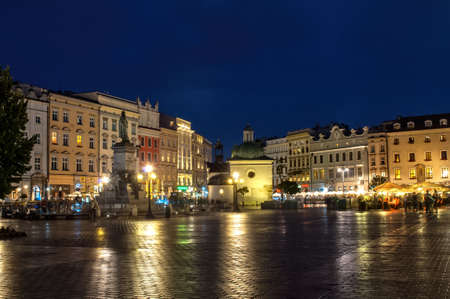 Krakow, Poland - 18 July 2016: Night view of the illuminated main square with lots of old houses and reflections on the sidewalkのeditorial素材