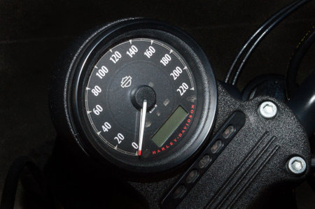 Black speedometer and display and white hand on a fast expensive motorbike